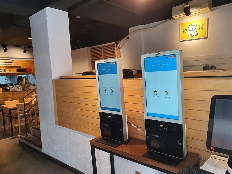 홀 벽면에 나란히 둔 키오스크와 포스