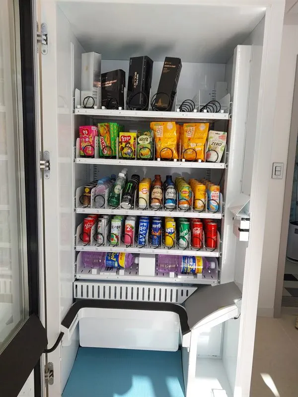 문을 연 자판기 안쪽 — 음료와 과자 진열